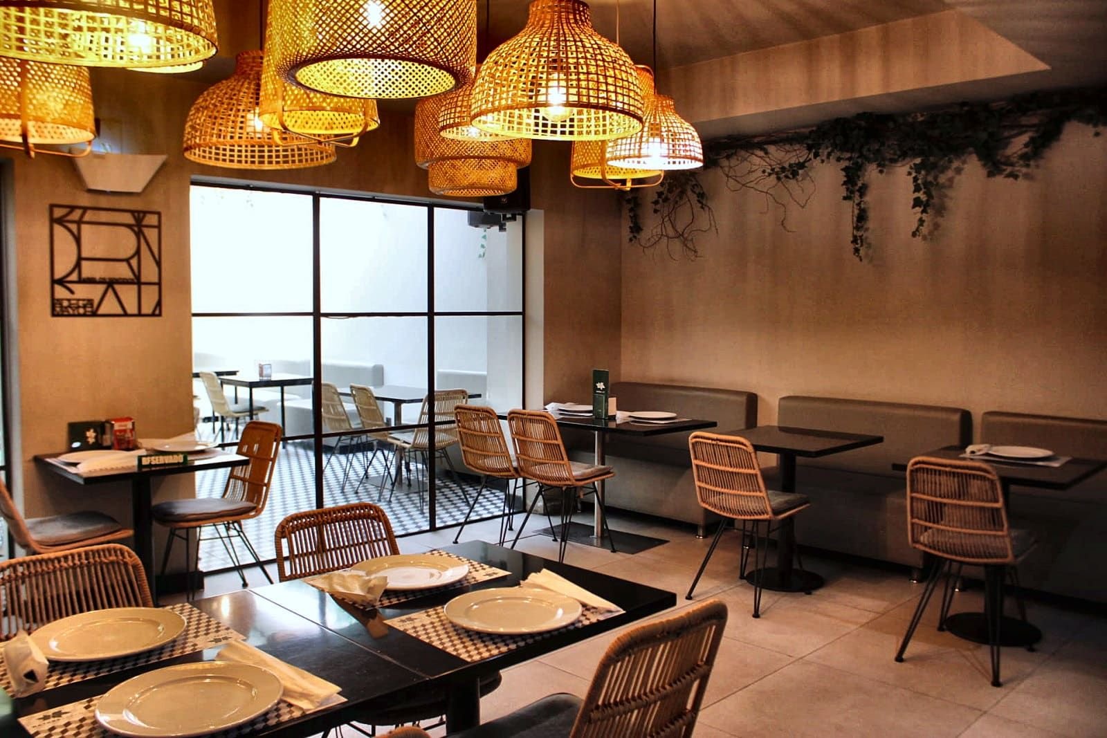 Interior do Natura Caffé com cadeiras de rattan e candeeiros de vime