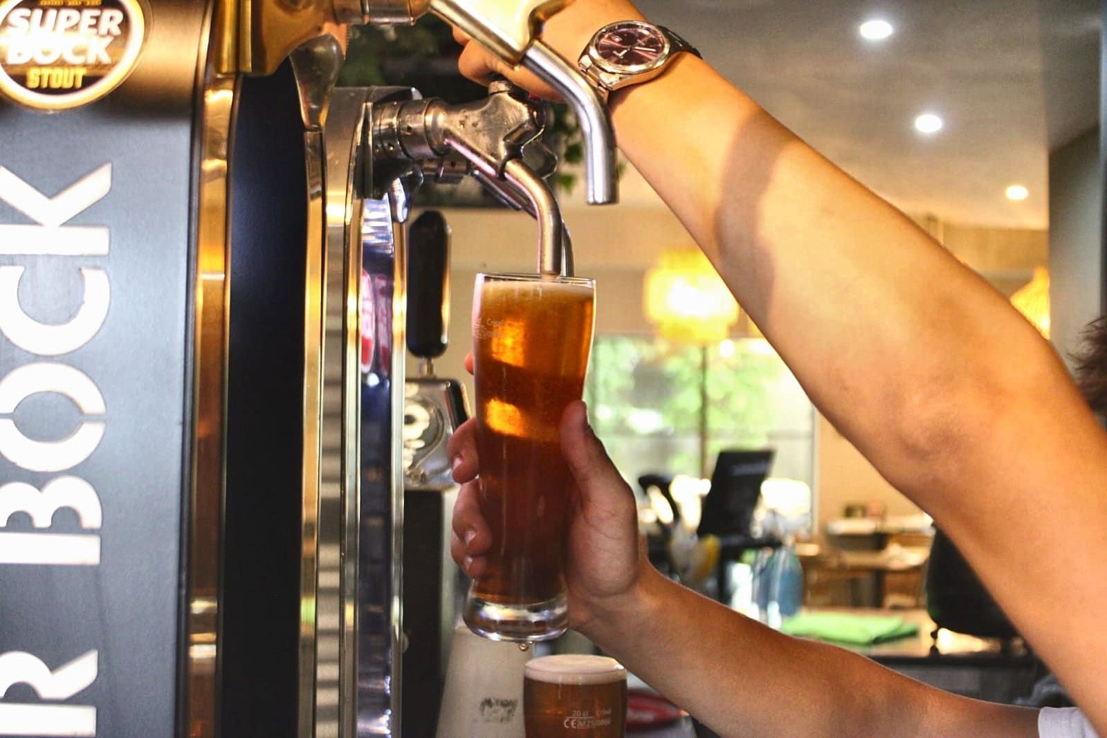 Empregado a tirar um fino de Super Bock no bar do Natura Caffé em Lousada